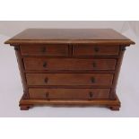 An Edwardian rectangular mahogany miniature chest of drawers on four bracket feet, possibly an