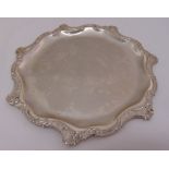 A continental white metal shaped circular card tray with scroll and leaf border, approx total weight