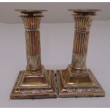 A pair of silver dwarf table candlesticks, of fluted columnular form on raised square bases with