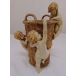 An Austrian late 19th century ceramic vase in the form of a basket with three applied putti, 33cm (