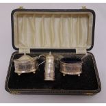 A three piece silver condiment set, bar pierced sides with two condiment spoons all in fitted