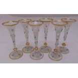 A set of six French hand painted liqueur glasses with gilded rims and raised circular bases