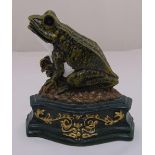 A cast iron door stop in the form of a hand painted frog on shaped rectangular plinth, 19cm (h)