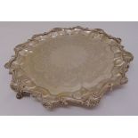 A Victorian silver salver, circular with shell and scroll border on three scroll supports, London