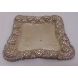 An American white metal shaped square card tray with raised scroll embossed border, stamped