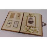 A Victorian leather bound photograph album with gilded metal clasp to include old sepia photographs