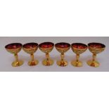 A set of six continental red champagne glasses with gilded and coloured detail