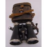 A pair of early 20th century binoculars with integral compass in fitted leather case