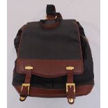 A Dunhill leather and canvas rucksack with metal buckles and mounts