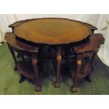 A circular walnut coffee table with piecrust border, scroll legs, ball and claw feet with four