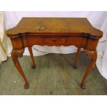 A late 19th century rectangular mahogany games table on four carved legs with hinged top and