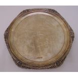 A silver salver, circular with gadroon and shell border on three feet, Sheffield 1914, approx weight