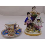 A continental porcelain figural group of three children on raised oval base and two handle chocolate