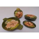 A quantity of Moorcroft Hibiscus pattern to include a covered dish, two dishes and a table