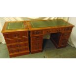 A rectangular yew wood desk with tooled leather top, nine drawers with brass swing handles