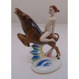 A continental Art Deco style porcelain figurine of a naked girl riding an antelope on raised