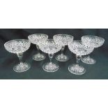 A set of six cut crystal champagne glasses with baluster stems on star cut bases