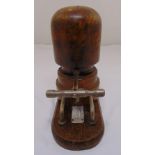 An early 20th century wooden milliners hat stretcher with metal gauge on rounded rectangular base