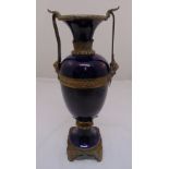 A late 19th century French blue glazed ceramic vase of classical form with gilded metal mounts on