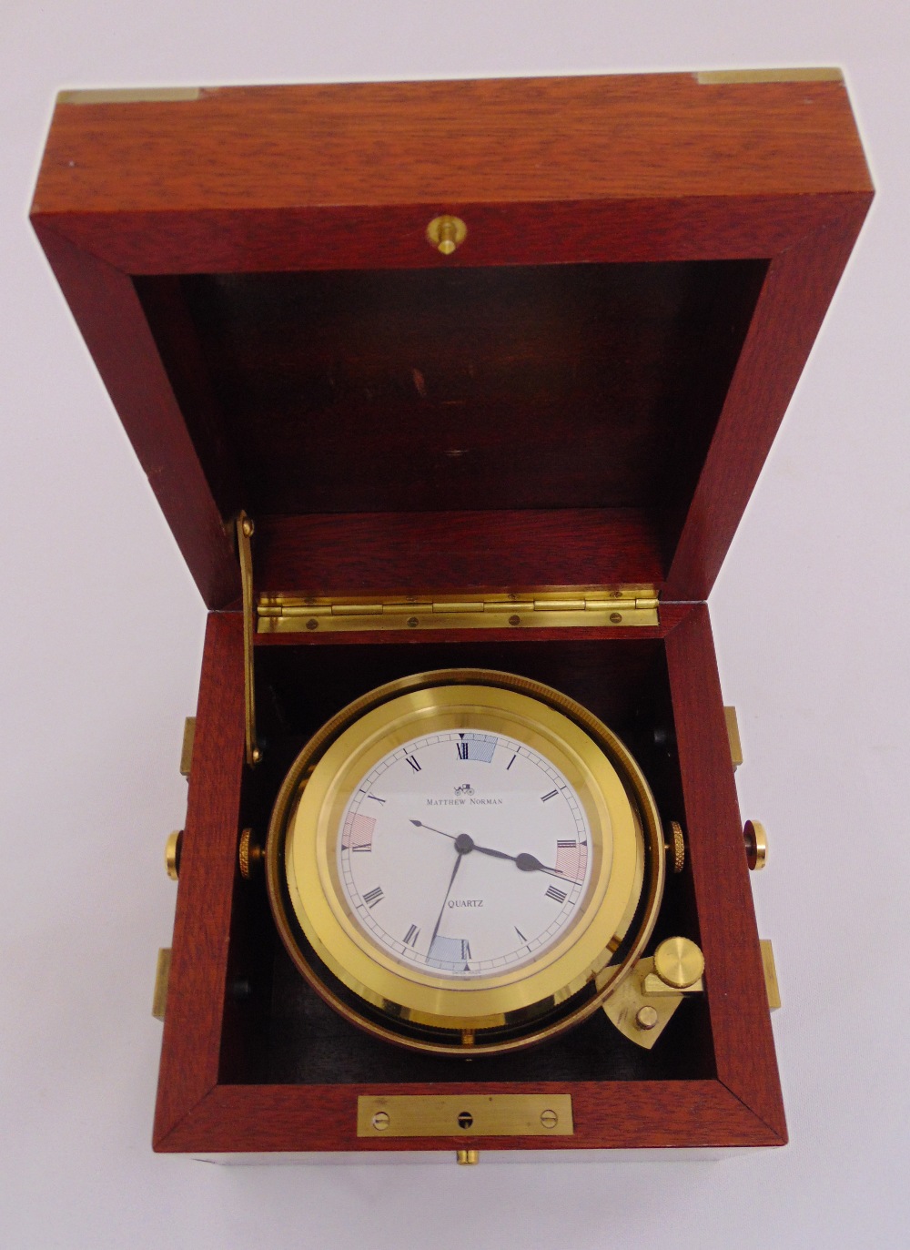 Matthew Norman a quartz nautical gimbal mounted clock in wooden case with hinged cover and brass