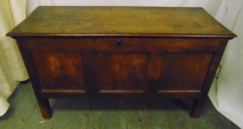 A rectangular oak coffer of panelled form with hinged cover on four rectangular legs, 65.5 x 112.5 x