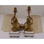 A pair of late 19th century continental ormolu putti supporting light fittings on square marble