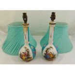 A pair of continental porcelain table lamps decorated with 18th century courtship scenes with silk