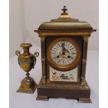 A brass mantle clock with enamel dial and Roman numerals and a single vase form garniture, 38cm (h)