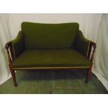 An Edwardian two seater settle with upholstered seat and back on tapering rectangular legs