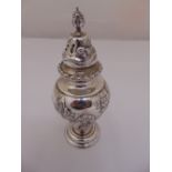 A Victorian silver sugar sifter, pear shaped, scroll and florally chased sides, London 1899 by