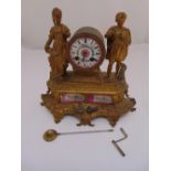 French 19th century gilt metal mantel clock, flanked by two figurines on raised shaped rectangular