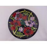 A Moorcroft plate decorated with flowers in original presentation packaging, 26cm dia