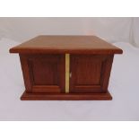 A rectangular mahogany coin cabinet by Peter Nichols Cabinet Makers, the hinged doors revealing