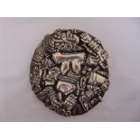 A white metal wall plaque cast with Aztec images
