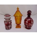 An amber glass vase and cover and two Victorian coloured glass containers with drop stoppers