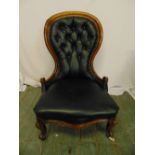 A Victorian black leather button back ladies chair on scroll legs