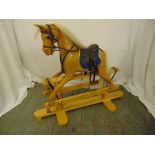 Robert Mullis wooden rocking horse of customary form with leather reins and saddle, 89 x 104 x 40cm