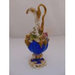 A continental 19th century floral encrusted porcelain wine ewer, blue and gilt painted on raised