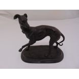 A bronze figurine of a greyhound on raised oval plinth, 24 x 34 x 13cm