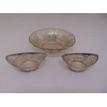A white metal circular fruit basket with scroll pierced sides and a pair of white metal oval