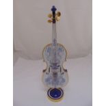 A life size porcelain violin on stand with gilded borders and stylised floral decoration on raised