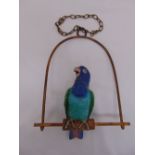A polychromatic porcelain parrot, realistically modelled on brass swing with suspensory chain