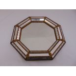 An octagonal gilded metal mounted wall mirror with raised bevelled border, 40.5 diameter