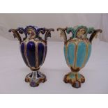 Two continental ceramic vases of lobed oval form with scrolling side handles on raised quatrefoil