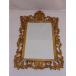 A gilded wooden rectangular, leaf and shell carved wall mirror in the Rococo style, 100 x 68.5cm