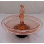 An Art Deco pink glass centrepiece in the form of a female figure on a black glass circular stand,