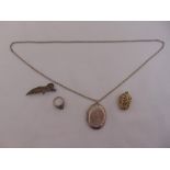 A quantity of silver and white metal to include a ring, a locket on a chain, a brooch and a