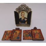 A framed portrait of Eva Peron and two painted wooden icons