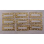 Nine Dresden porcelain rectangular place name panels decorated with flowers and scrolls, 9 x 4cm