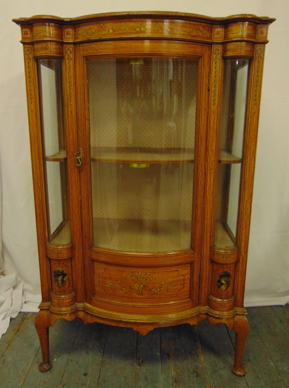 An Edwardian mahogany and satinwood glazed display case shaped rectangular with bow front, decorated